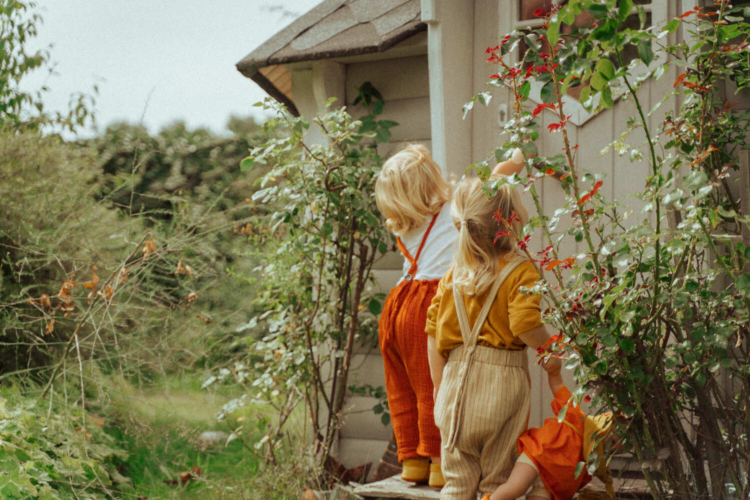 Lifestylefotografie zweier Kinder vor einem Gartenhäuschen – Werbefotografie Nürnberg