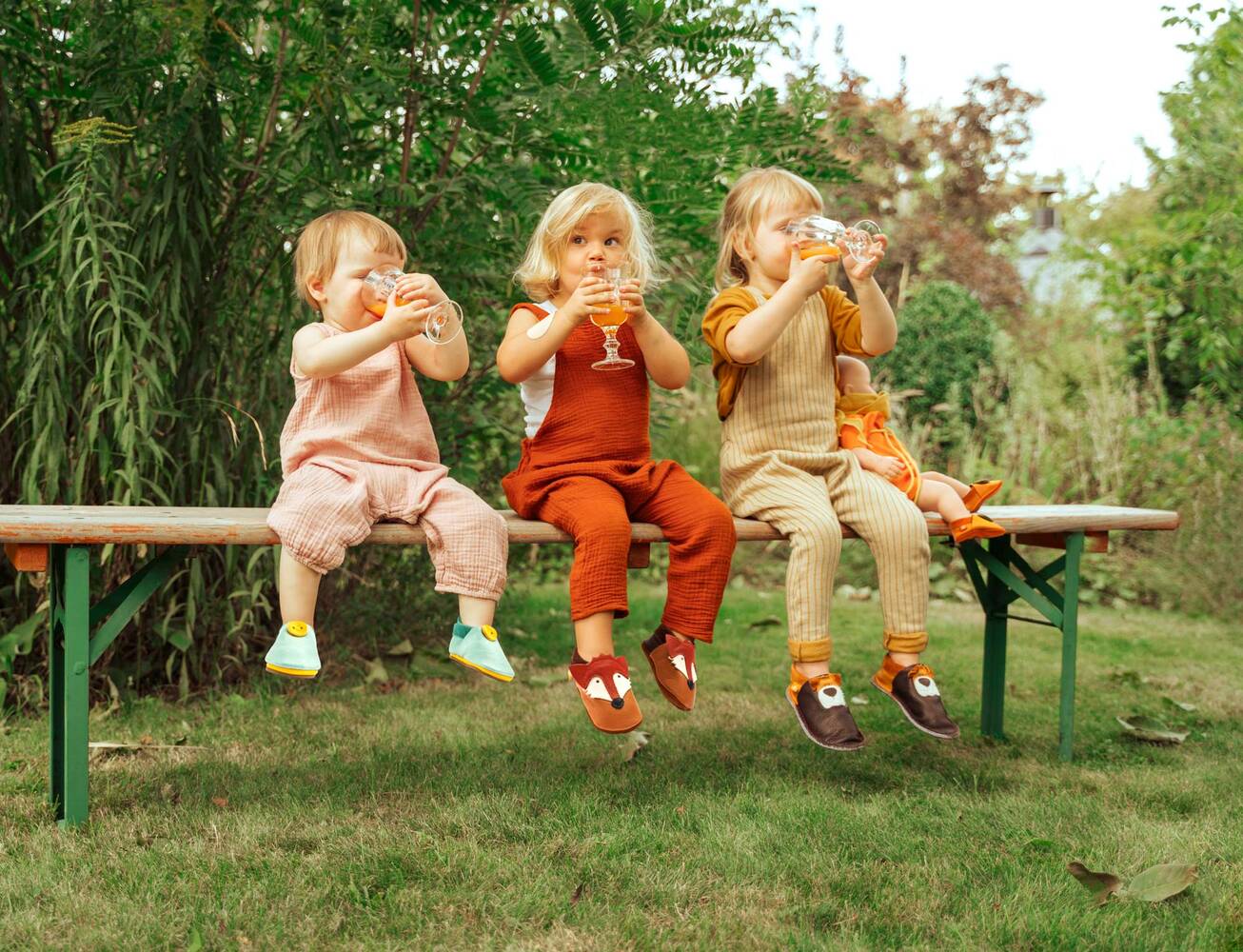 Lifestylefotografie dreier Kinder auf einer Bank in einem Garten – Werbefotografie Nürnberg