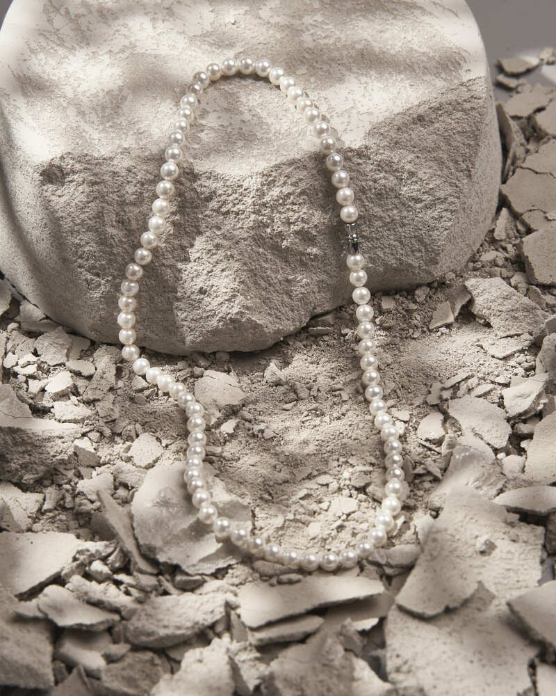 Produktfotografie einer Perlenkette inszeniert auf einem Betonblock – Werbefotografie Nürnberg